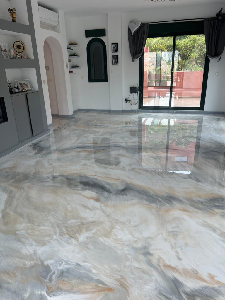 Glossy decorative resin floor with flowing white, grey and warm gold marble effects in a living room
