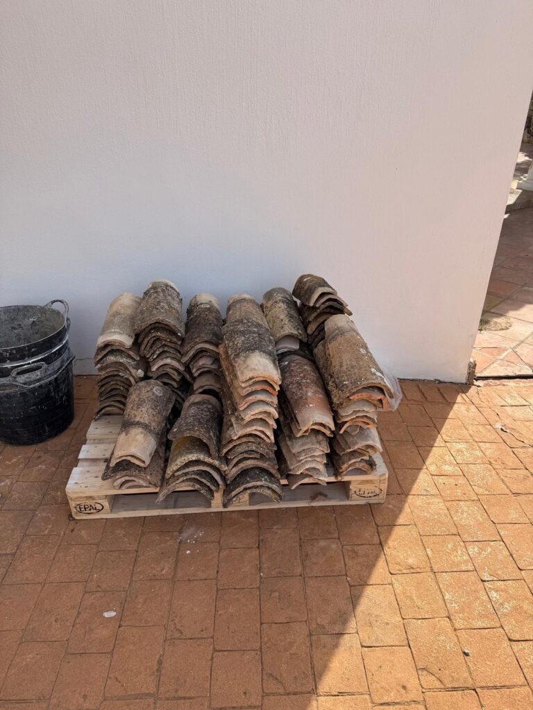 Salvaged clay roof tiles stacked on a pallet